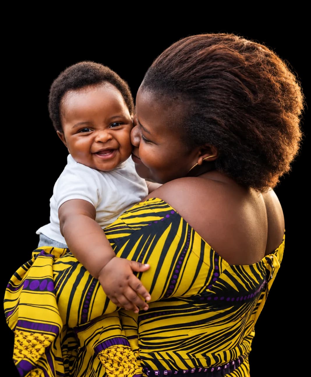 A mother kisses her laughing baby.